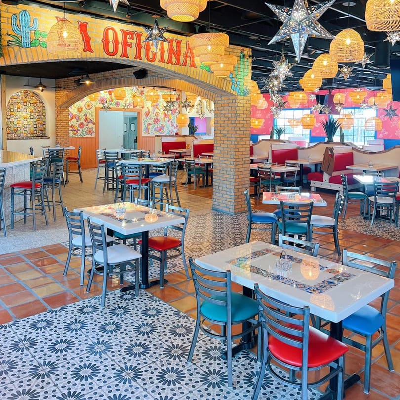Vibrant El Paso Tacos & Tequila dining room with colorful murals, star lanterns, and diverse seating.