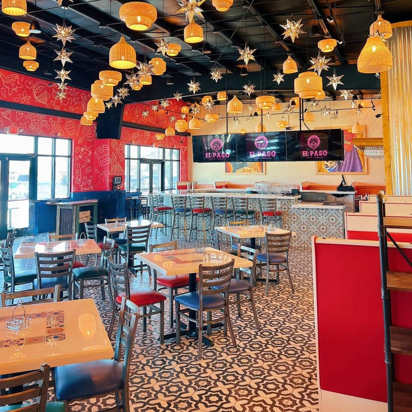 Vibrant El Paso Tacos & Tequila dining room with red walls, patterned floor, and star-shaped lights.