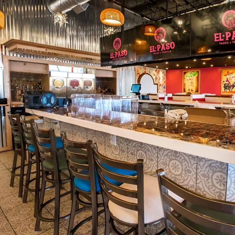 El Paso Tacos & Tequila bar with stools, margarita machines, and vibrant Mexican decor.