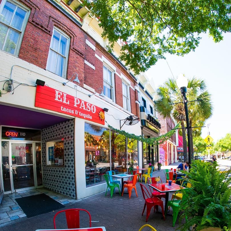 El Paso Tacos & Tequila restaurant exterior with colorful outdoor seating on a sunny day.
