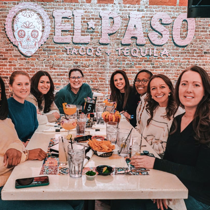 Group of women smiling at a table with drinks and chips at El Paso Tacos & Tequila.